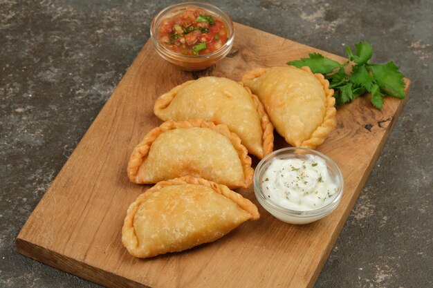 Foto empanadas de pollo relleno caseras servidas con salsa de fondo