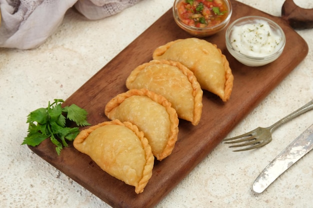 Foto empanadas de pollo relleno caseras servidas con salsa de fondo