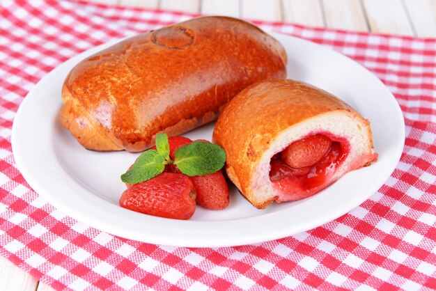 Empanadas recién horneadas con fresas en un plato en el primer plano de la mesa