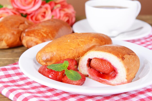 Empanadas recién horneadas con fresas en un plato en el primer plano de la mesa