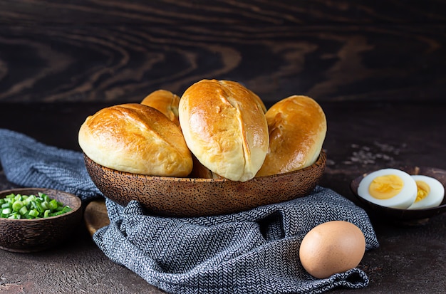 Empanadas recién horneadas con relleno de huevo y cebolla verde. Pirozhki ruso tradicional.