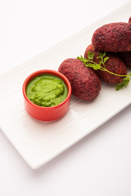 Empanadas de remolacha o chuleta o tikki servidas con chutney verde