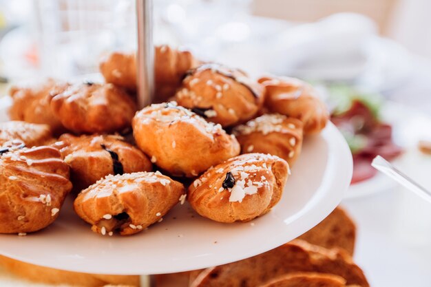 Empanadas con semillas de sésamo en un plato de varios niveles. Mesa de buffet en la fiesta.