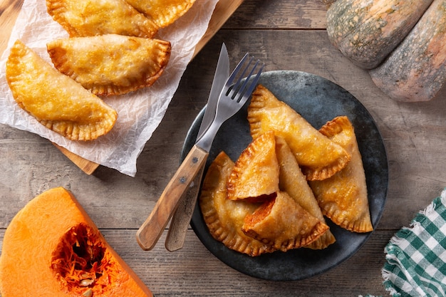 Foto empanadillas de calabaza en mesa de madera