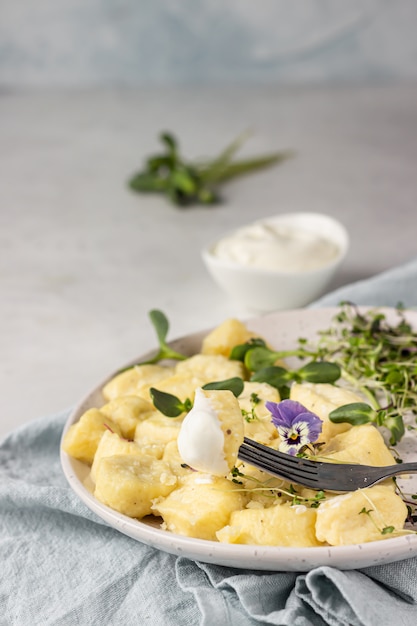 Empanadillas de cuajada servidas con microgreens y crema agria