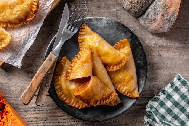 Empanadillas de abóbora na mesa de madeira.