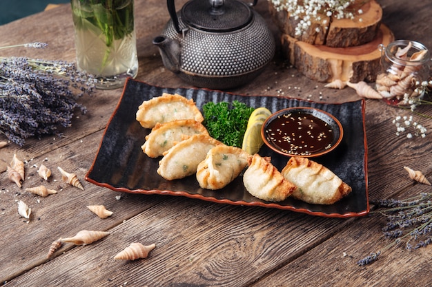 Empanadillas japonesas fritas salsa de gedza mesa de madera