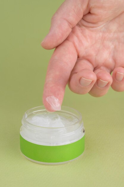 Empaque blanco de envases de productos en forma de frasco de crema en la mano de la mujer Empaque de contenedor