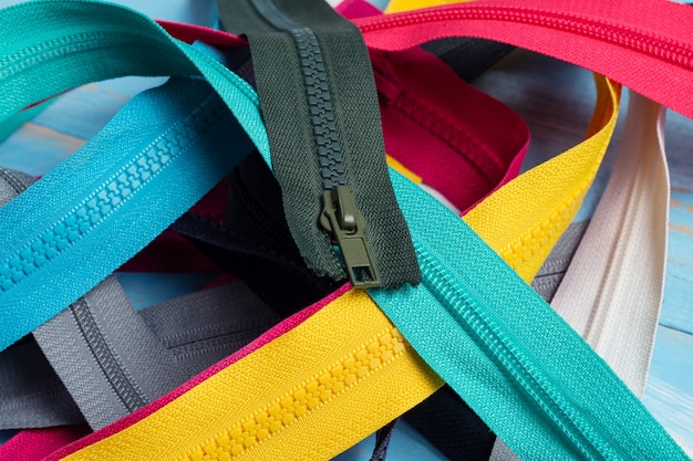 Empaque una gran cantidad de coloridas rayas de cremalleras de plástico y metal con patrón de deslizadores para coser a mano