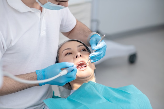 Empaste dental. Dentista trabajando en la restauración de los dientes de los pacientes y haciendo empastes dentales