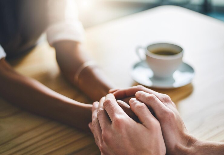 Foto empatía tomándose de la mano y apoyo en la mesa para la solidaridad empresarial y del socio en la empresa y juntos unidad empresario y la gente en la liquidación de la oficina y el cierre de la puesta en bancarrota
