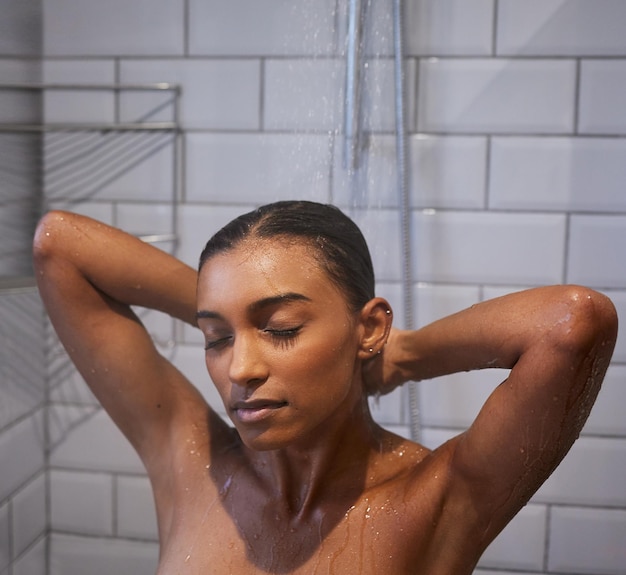 Empezar el día de una forma refrescante. Foto de una mujer joven duchándose en el baño de su casa.