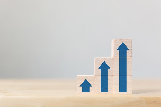 Empilhamento de blocos de madeira como escada com seta para cima