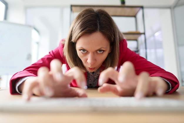 Foto empleada agresiva estira las manos escribiendo en el teclado blanco mujer trabajadora