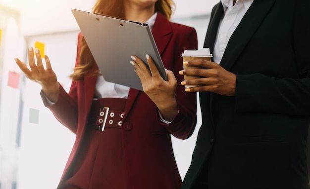 Foto empleada secretaria de empresaria exitosa profesional asiática que muestra datos de estrategia de información a través de una computadora portátil a un gerente de negocios masculino en traje de negocios formal en la sala de estar