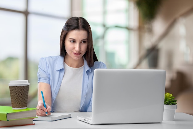 Empleada sonriente usando una computadora portátil en el lugar de trabajo