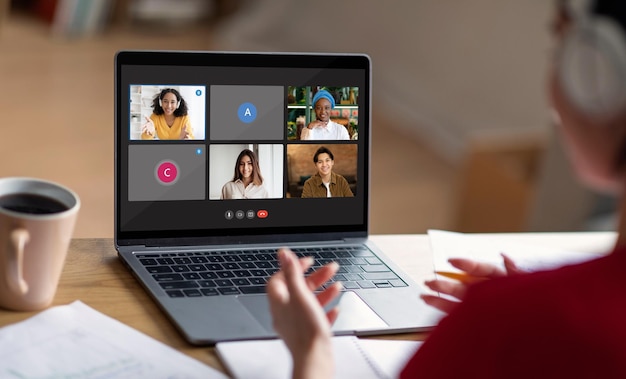 Una empleada tiene una conferencia grupal por webcam con sus compañeros de trabajo