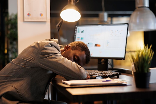 Empleado adicto al trabajo durmiendo en el escritorio en la oficina de inicio después de trabajar horas extras en el plan de inversión Gerente durmiendo solo en la empresa después de terminar el trabajo de gestión Concepto de negocio