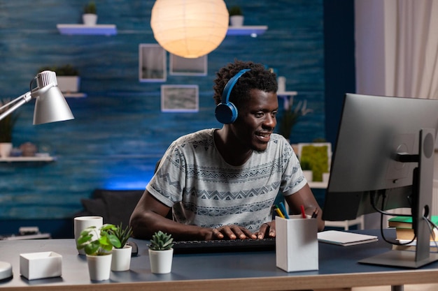 Empleado afroamericano con auriculares escribiendo ideas de marketing