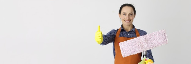 Empleado de la empresa de limpieza con trapeador sostiene recomendaciones de gestos de aprobación para la calidad