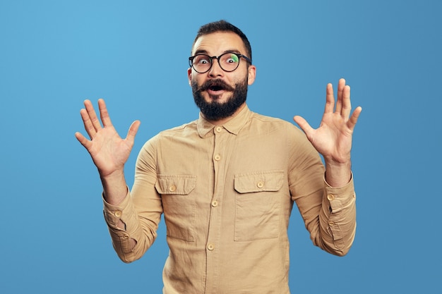 Empleado joven confundido exclamando en estado de shock y con total incredulidad gesticulando