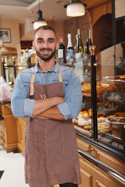 Empleado joven guapo en una panadería