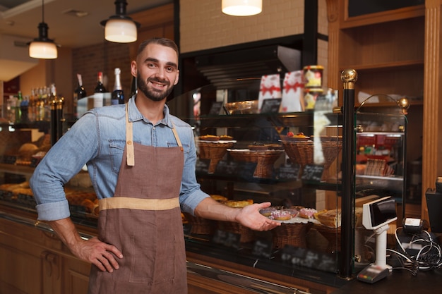 Empleado joven guapo en una panadería