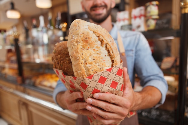 Empleado joven guapo en una panadería