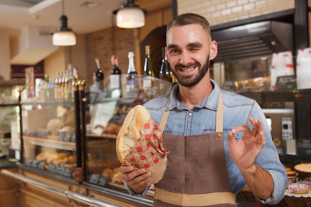 Empleado joven guapo en una panadería