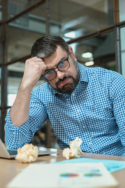 Empleado masculino cansado de la tarea difícil en la oficina