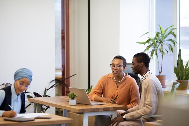 Empleado masculino conversando con sus nuevos colegas en el trabajo de oficina