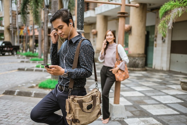 Empleado masculino en la plaza de la oficina esperando el autobús