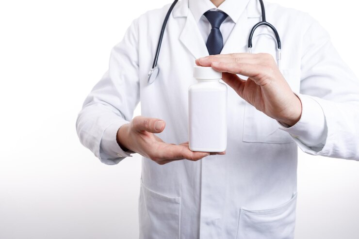 Empleado médico demostrando una botella de medicamentos que sostiene
