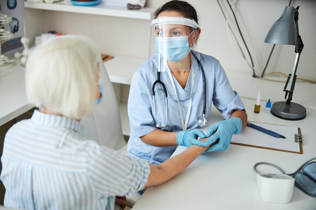 El empleado médico está realizando un control de pulso