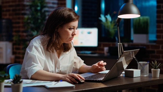 El empleado de la oficina frunciando la cara ante la pantalla de la computadora portátil sintiéndose molesto