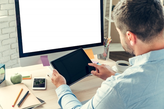 Empleado de oficina haciendo su trabajo sentado en su mesa de trabajo con una computadora