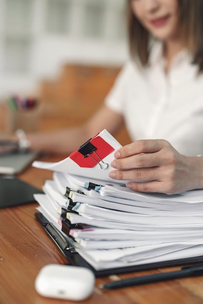 Empleado de oficina joven que trabaja con documentos y computadora portátil en la mesa