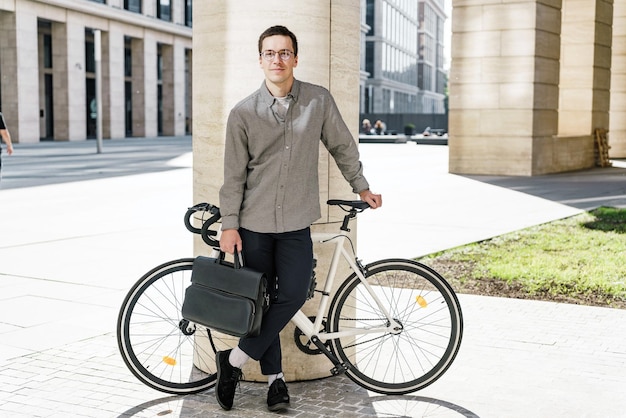 Un empleado de oficina que va al trabajo en bicicleta con una bolsa a la oficina en un ecotransporte