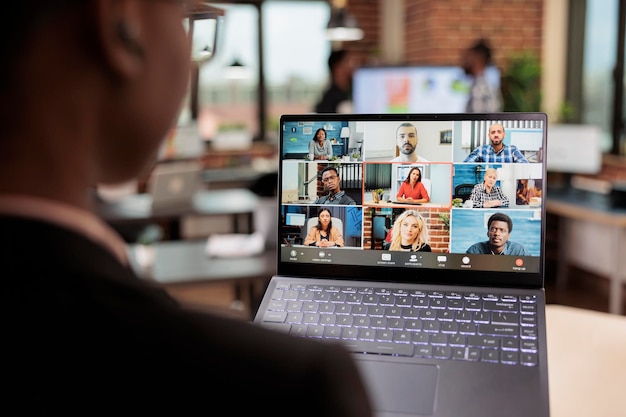 Empleado de oficina que asiste a una reunión de negocios en una videollamada remota, usa una computadora portátil y una cámara web para hablar con colegas en el chat de teleconferencia en línea. Hablando en llamada de videoconferencia para telecomunicaciones.