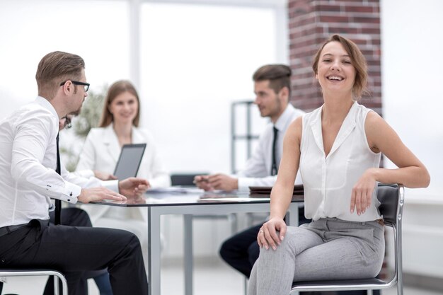 Empleado sonriente y equipo de negocios sentado en el concepto Deskthe de trabajo en equipo