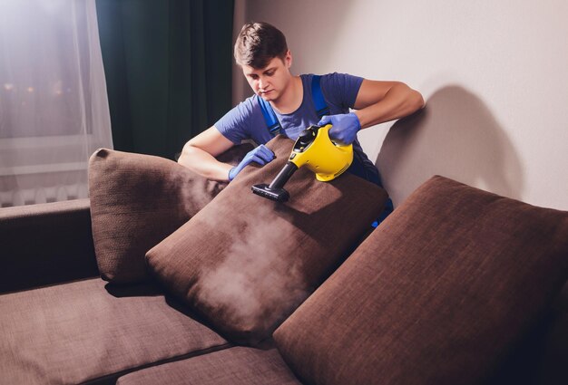 Foto empleado de la tintorería quitando la suciedad de los muebles en un primer plano plano