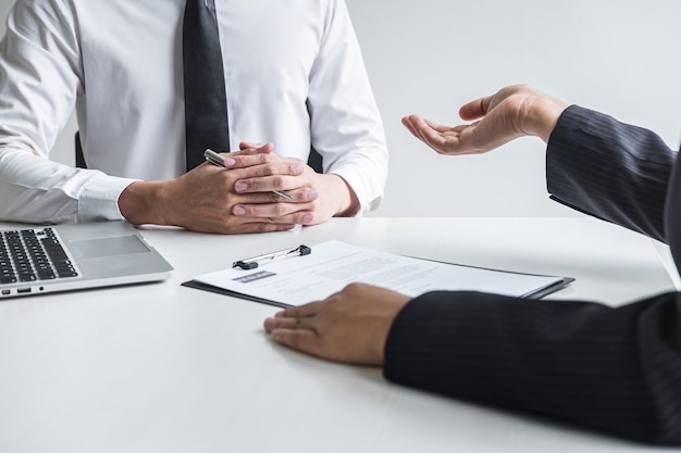 Foto el empleador o el comité que lee un currículum habla durante su perfil de candidato, el empleador en traje está realizando una entrevista de trabajo, el empleo de recursos del administrador y el concepto de contratación.