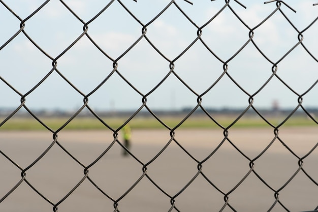 Foto los empleados del aeropuerto están en la pista. el territorio del aeródromo privado está cercado con alambre de púas y una valla. el controlador de tráfico dirige el avión.