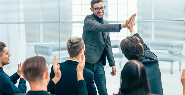 Empleados dándose un máximo de cinco durante una reunión de trabajo