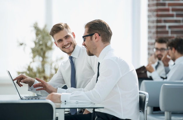 Empleados discutiendo nueva información sentados en Deskoffice entre semana