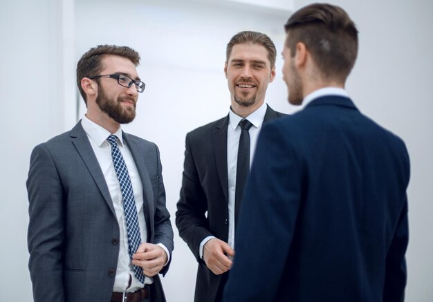 Empleados discutiendo nuevas ideas de pie en el vestíbulo de la oficina entre semana