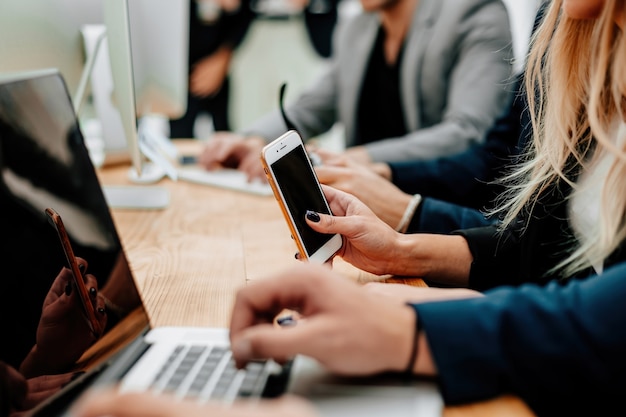 Empleados con dispositivos inteligentes sentados en el escritorio