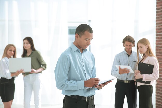 Empleados de la empresa antes de la reunión de pie en el vestíbulo de la oficina.