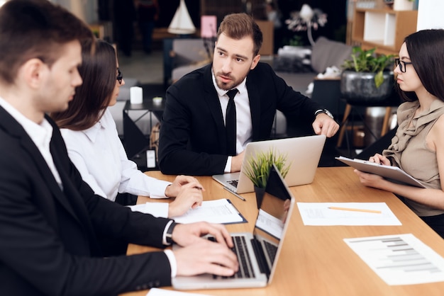 Empleados de la empresa celebran una reunión en la mesa.