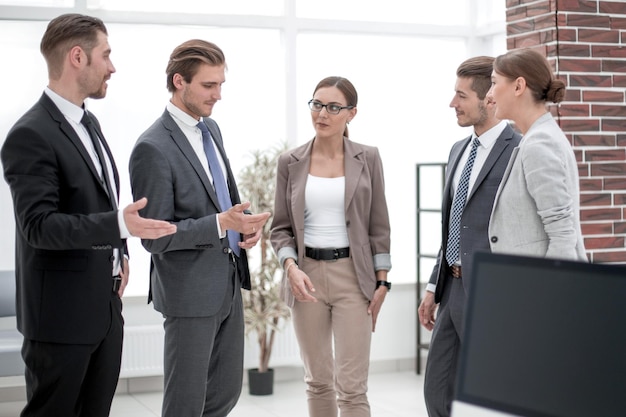 Empleados de la empresa discutiendo de pie en la oficina entre semana